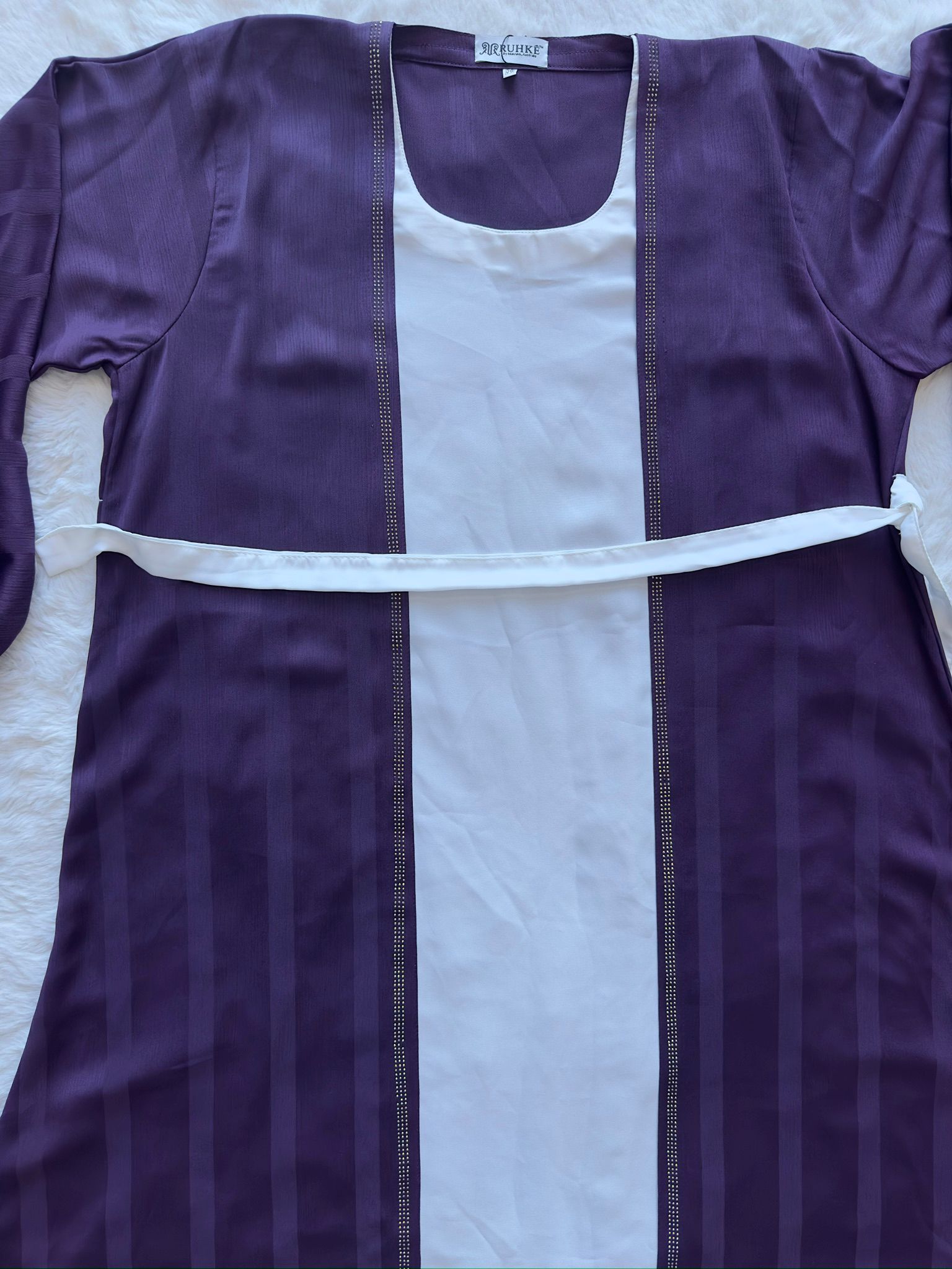 High-end deep plum flared silk abaya showcasing rich texture and fluid movement with belt