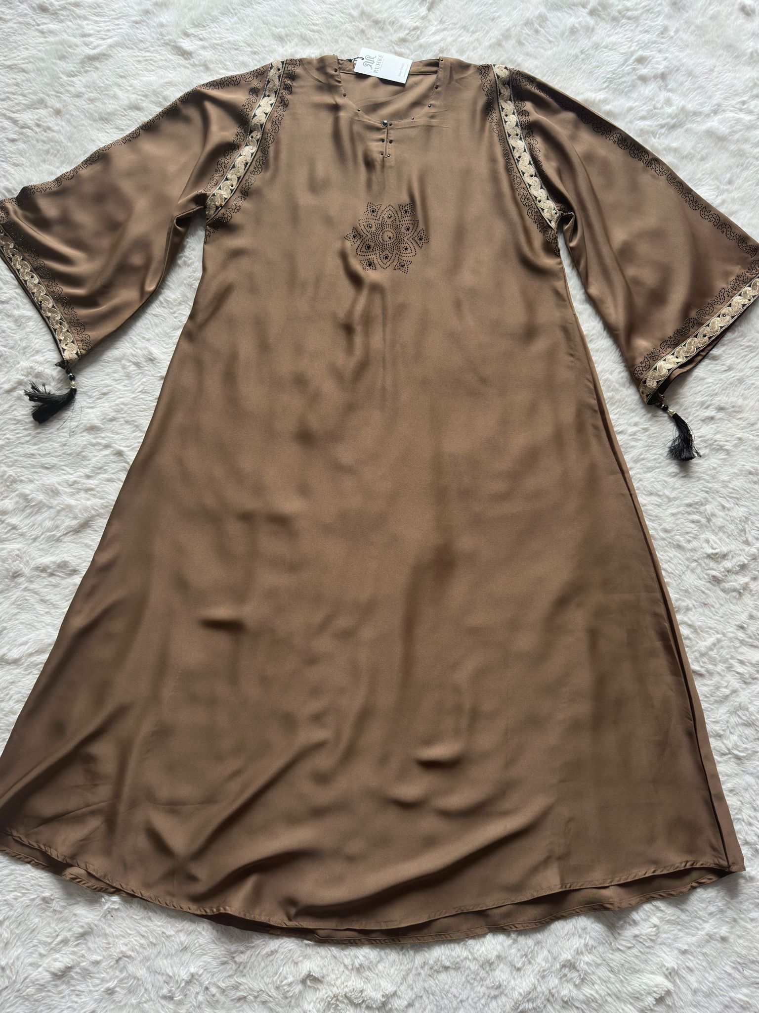 Premium nida fabric black abaya with gold thread detailing, crystal stone work and tassel arm design flat lay