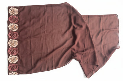 Brown fabric with floral embroidery on a textured white background