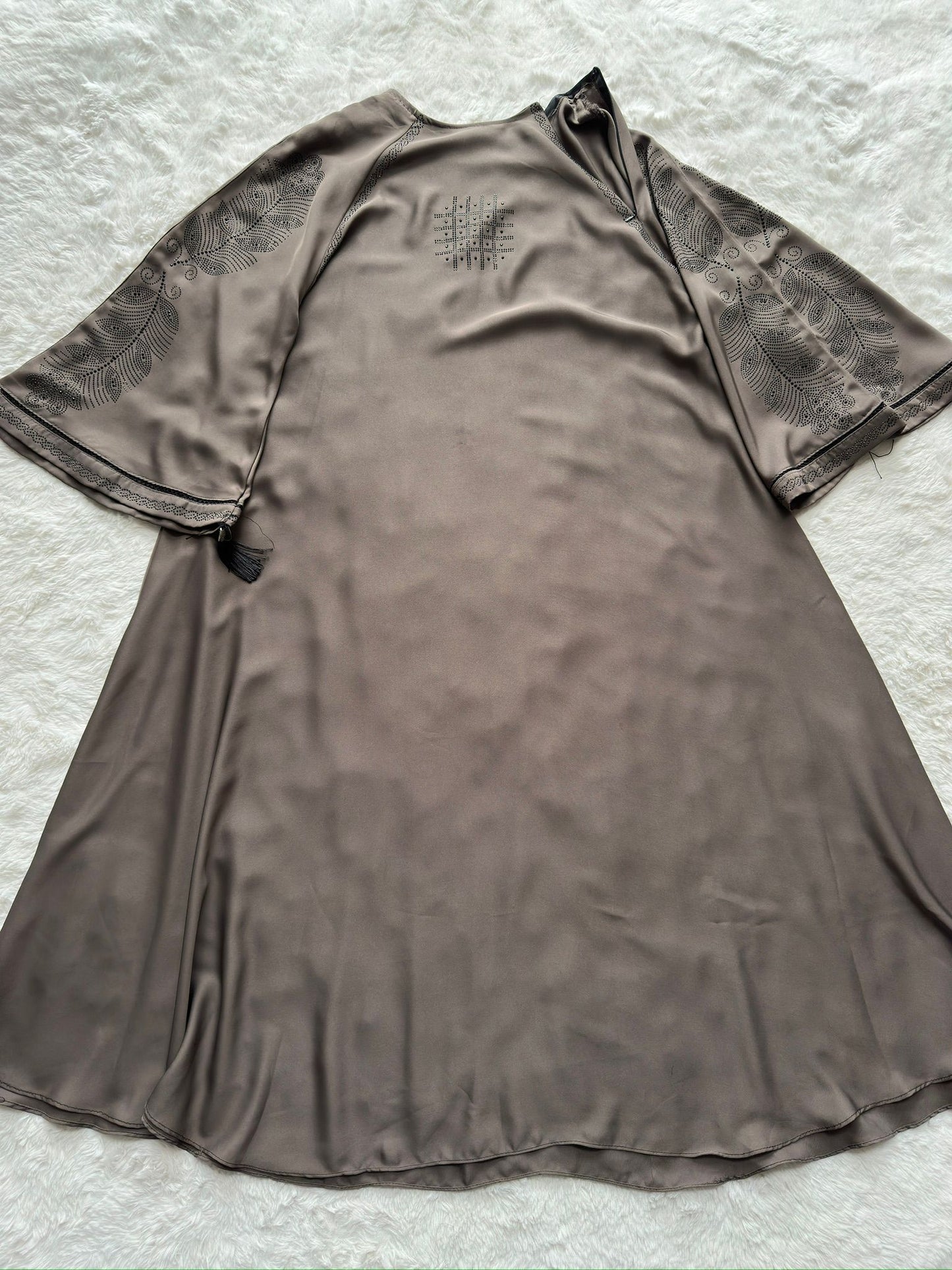 Front view of luxury grey Nida abaya with soft flowing flare, minimal chest detailing and embroidered cut-work sleeves