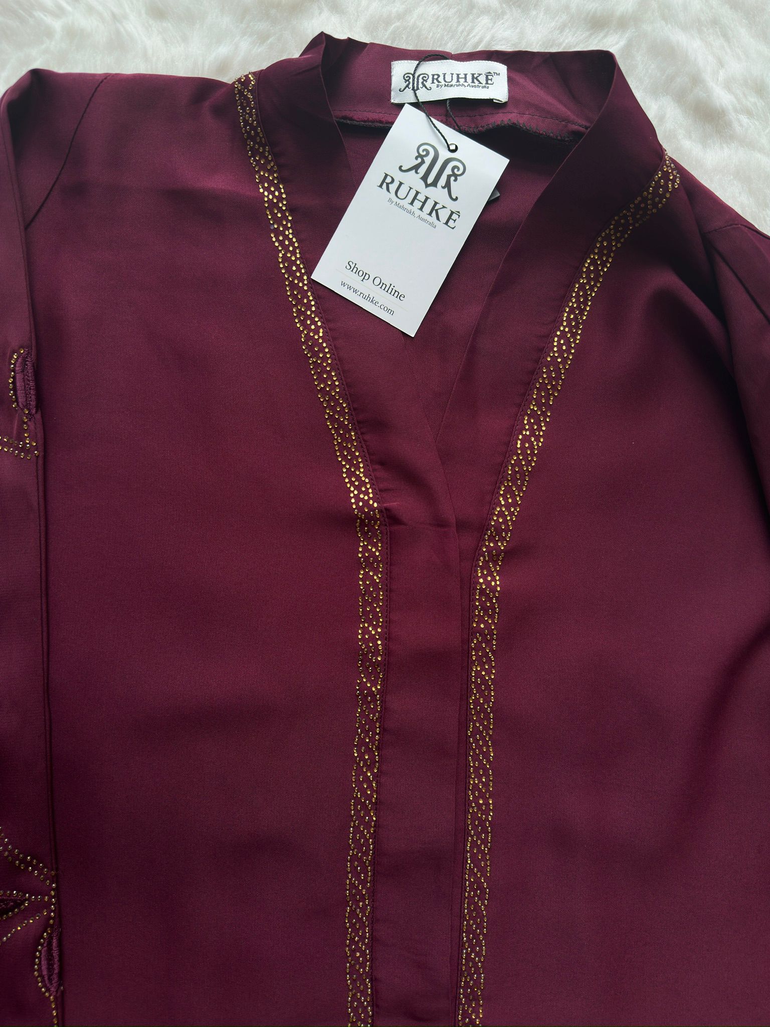 Close-up of maroon premium Nida abaya showing gold stone neck with 