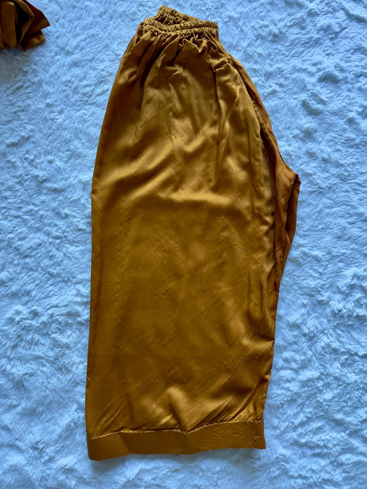 Gold pants on a textured blue surface