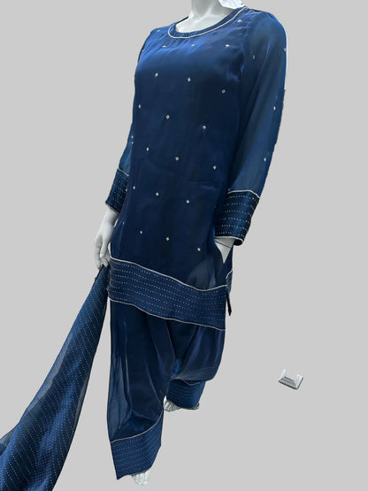 Blue outfit with white embellishments on a mannequin against an urban background