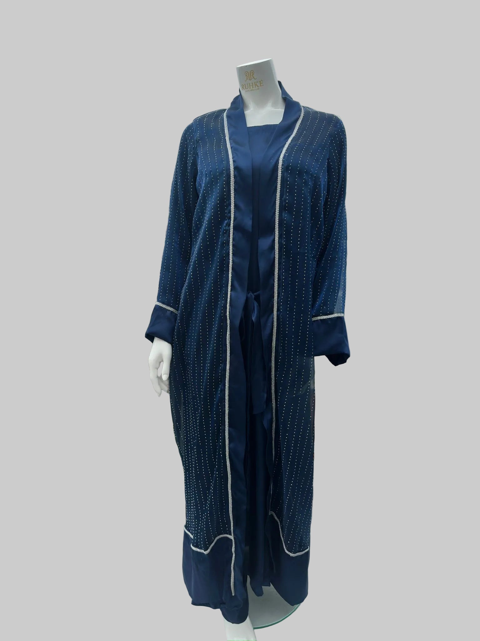 Navy blue textured dress with white piping on a mannequin against an urban rooftop background.