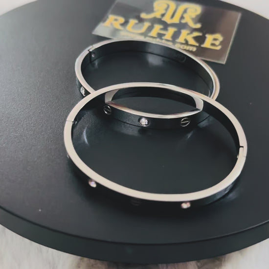 Luxury silver bangle bracelet with alternating crystal stones and linear screw details, captured on video